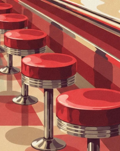 Les tabourets rouges aux pieds chromés alignés le long du comptoir du diner