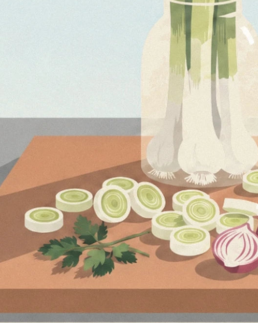 Leek slices, fresh parsley and a red onion on the wooden chopping board