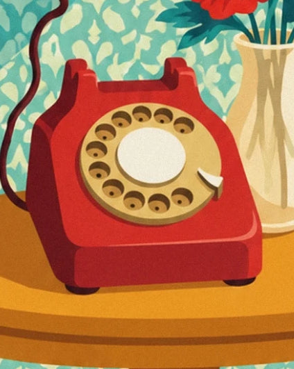 The red telephone with its gold dial on the side table, beside a cream vase