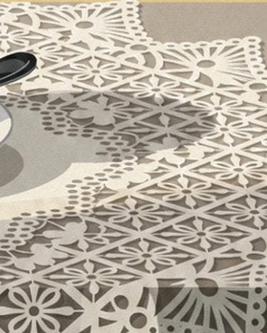 La dentelle ivoire aux motifs de fleurs et de losanges sur fond gris beige