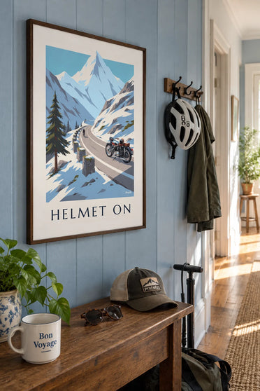 Poster of a motorcycle and full-face helmet at the top of a mountain pass: framed on a wall
